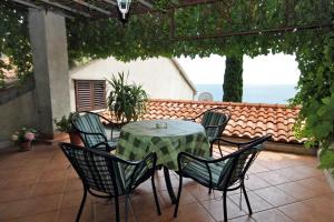 un tavolo e sedie su un patio con vista sull'oceano di Apartments with a parking space Dubrovnik - 4673 a Dubrovnik