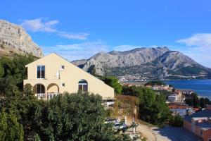 a house on a hill with mountains in the background at Apartments with a parking space Duce, Omis - 4663 in Duće
