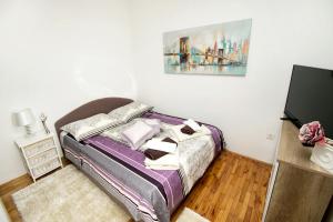 - une chambre avec un lit et une peinture murale dans l'établissement Apartments with a parking space Duce, Omis - 4663, à Duće