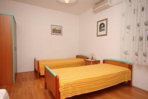 two beds in a room with white walls and wooden floors at Studio Nemira 4652c in Tice
