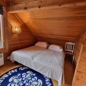 ein Schlafzimmer mit einem Bett in einem Blockhaus in der Unterkunft Revontulen Tupa in Kaamanen