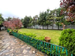 Jowai的住宿－Odyssey Stays Jowai - West Jaintia Hills，一个带蓝色栅栏和灌木的花园
