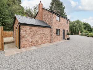 a brick building on a gravel driveway at The Old Mill Bake House in Ross on Wye