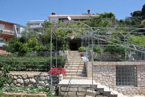 einen Garten mit einer Treppe, die zu einem Gebäude führt in der Unterkunft Studio Palit 3195f in Rab + 10 Fotos