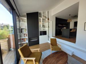 a living room with a table and chairs and a kitchen at La Saumonerie - Charmante maison a 200m de la plage de Wimereux in Wimereux