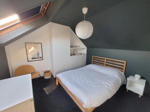 a small bedroom with a bed in a attic at La Saumonerie - Charmante maison a 200m de la plage de Wimereux in Wimereux