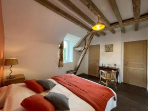 Un dormitorio con 2 camas y una mesa en una habitación en Les Colas en Saint-Fargeau