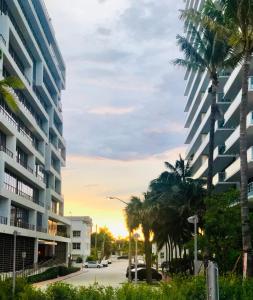 a street with palm trees and a tall building at Condo 103 in Miami Beach