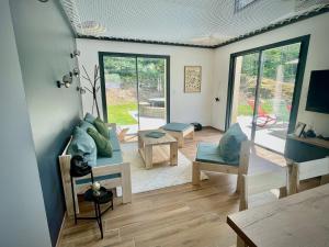a living room with a couch and chairs and windows at L’Éterle, maison de montagne in Aucun