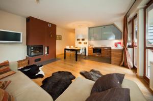 a living room with a couch and a kitchen at Apartments Zakopane Center in Zakopane
