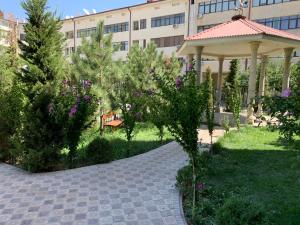 a garden with a gazebo and trees in front of a building at Samarkand luxury apartment #2 in Samarkand