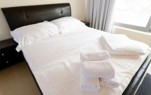 a bed with white sheets and towels on it at VergaView Luxury House in Kalamata