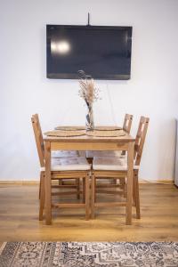 un tavolo in legno con due sedie e un vaso sopra di Arčiau Gamtos Nida a Nida