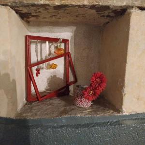 a vase with a flower sitting next to a window at La maison de l'échauguette in Ancenis