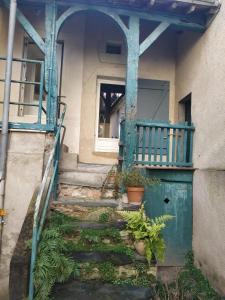 een ingang naar een huis met een blauwe deur en een trap bij La maison de l'échauguette in Ancenis