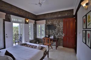 a bedroom with a bed and a desk at Chithirapuram Palace in Munnar