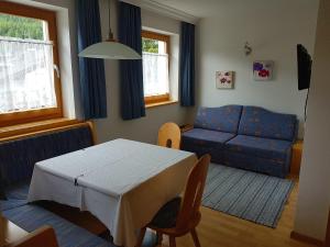 a living room with a table and a blue couch at Residence Majarai in Colfosco