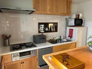 uma cozinha com um fogão e um frigorífico em Imakumano Terrace - Eisen An 潁川庵 em Quioto