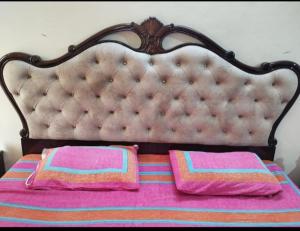 a bed with pink and pink pillows on it at The Villa in Gurgaon