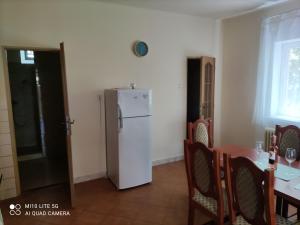 a kitchen with a table and a white refrigerator at Samostatný rodinný dom in Veľký Meder