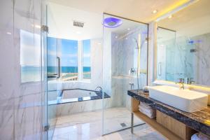 La salle de bains est pourvue d'une baignoire, d'un lavabo et d'une douche. dans l'établissement Kenting Long Beach Hotel, à Checheng