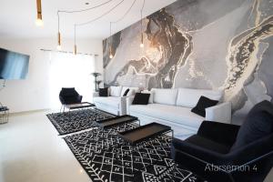 a living room with a white couch and black chairs at YalaRent Afarsemon Apartments with pool - For Families & Couples in Eilat