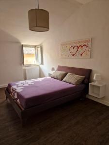 een slaapkamer met een paars bed in een kamer bij RESIDENZA DUOMO in Orvieto