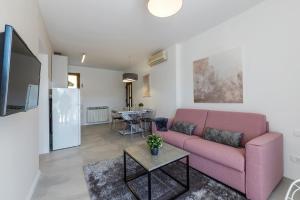 a living room with a pink couch and a table at Apartments with parking space Rabac, Labin - 3011 in Rabac