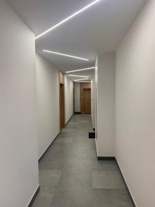 an empty hallway with white walls and tile floors at Nice to sleep You in Toruń
