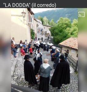 een groep mensen in het zwart die over straat lopen bij Casa vacanze al Castello in Villetta Barrea