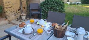 a blue table with food and orange juice on it at L'Amphitryon in Coudray