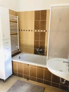 Erkel 19 Apartmanház في كيزتيلي: حمام مع حوض ومغسلة