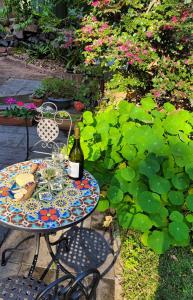 een tafel met een fles wijn en glazen bij Garden Rest in New Lambton