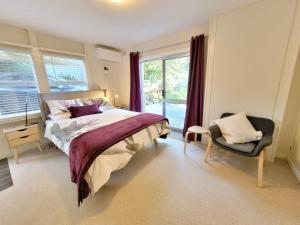 um quarto com uma cama, uma cadeira e uma janela em Garden Rest em New Lambton