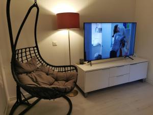 a living room with a chair in front of a tv at The White and Black House in Kalix