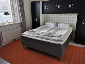 um quarto com uma cama com uma cabeceira preta em The White and Black House em Kalix