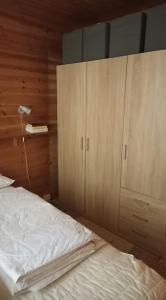 a bedroom with a bed and a wooden cabinet at Kelomökki Sallatunturissa in Salla