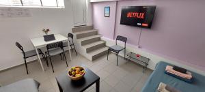 une salle d'attente avec une télévision, une table et des chaises dans l'établissement HoneyBee 1 - Sunny Studio in the center of Rafina, à Rafína