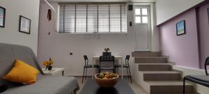 un soggiorno con divano e tavolo con cesto di frutta di HoneyBee 1 - Sunny Studio in the center of Rafina a Rafina