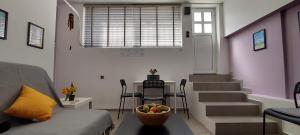 a living room with a couch and a table with a bowl of fruit at HoneyBee 1 - Sunny Studio in the center of Rafina in Rafina