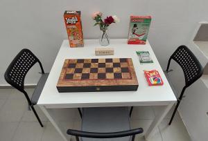 HoneyBee 1 - Sunny Studio in the center of Rafina في رافينا: لوحة شطرنج على طاولة مع كرسيين