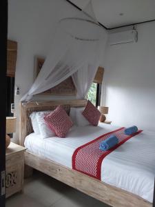 a bedroom with a bed with red and white pillows at Villa Gede Private Guest House in Selemadeg