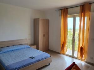 格里索利亞的住宿－b & b Magna Grecia，一间卧室设有一张床和一个大窗户