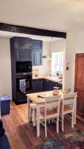 a kitchen with a table and chairs and a stove at Darnholm Cottage in Robin Hood's Bay