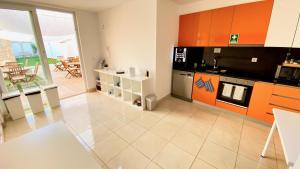 a kitchen with orange and white cabinets and a stove at Casa Amarela Guesthouse in Albufeira