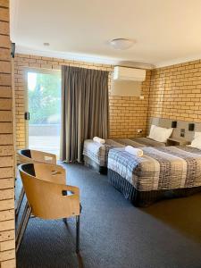 Habitación de hotel con 2 camas y ventana en Tallarook Motor Inn, en Dubbo