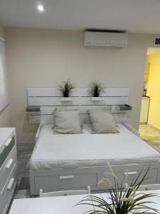 セビリアにあるApartamento en calle Rocio-Trianaのベッドルーム1室(植物2本が置かれたベッド1台付)
