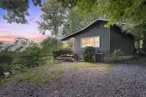 a black house with a fence in front of it at Blue Ridge Lookout Beautiful Modern Cabin - Nature Hikes and Pets OK cabin in Waynesville