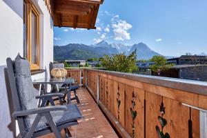 uma varanda com mesa, cadeiras e montanhas em Ferienwohnung Wetterstein em Garmisch-Partenkirchen