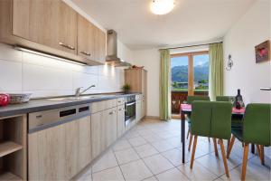 uma cozinha com uma mesa e cadeiras verdes em Ferienwohnung Wetterstein em Garmisch-Partenkirchen